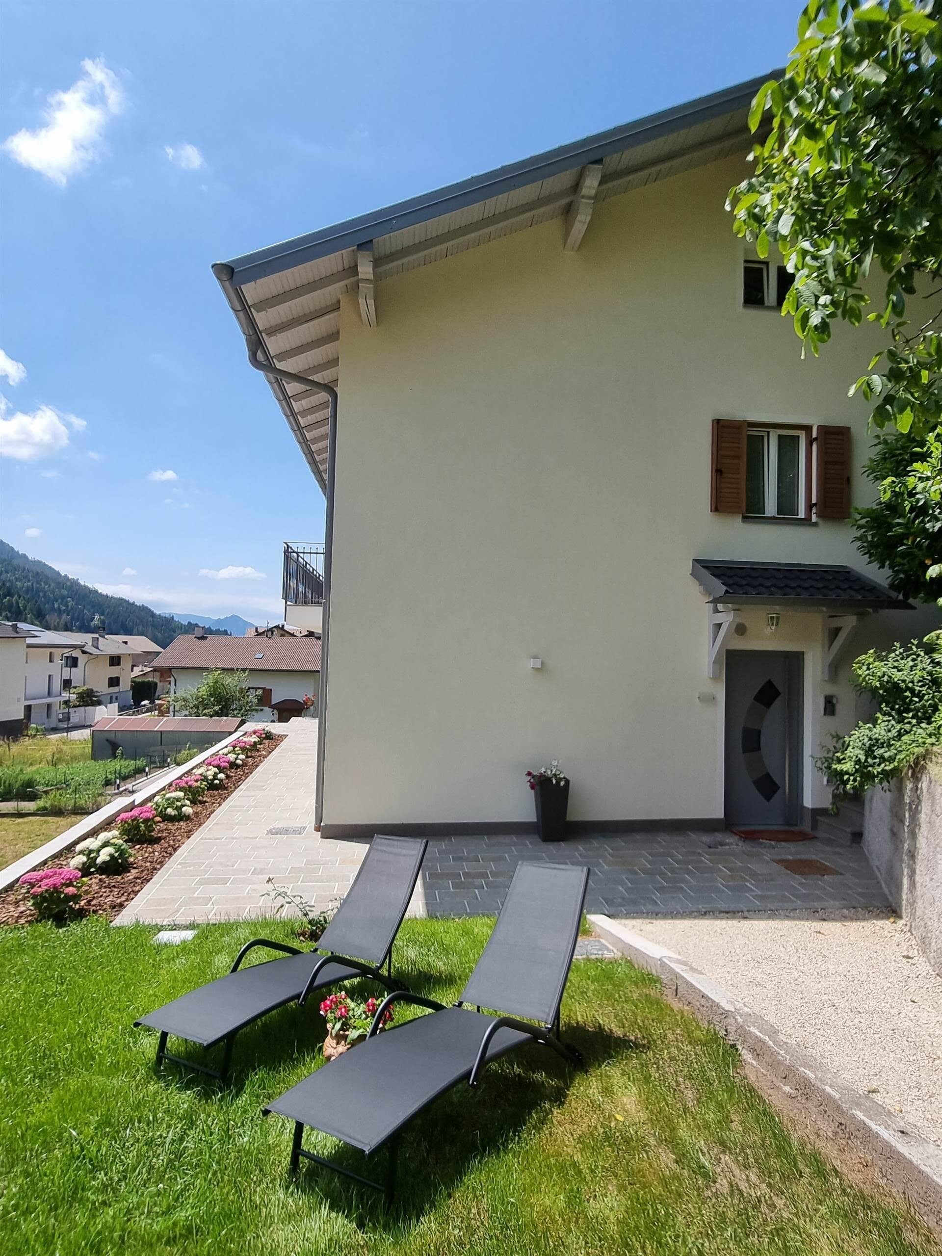 foto lato ingresso con giardino e sedie a sdraio